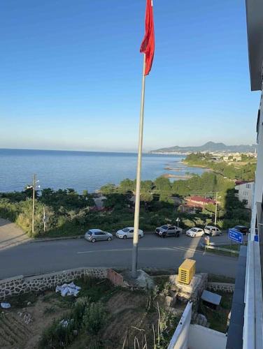 a flag on a pole in front of a parking lot at Plaja yakın konforlu aile yuvası in Piraziz