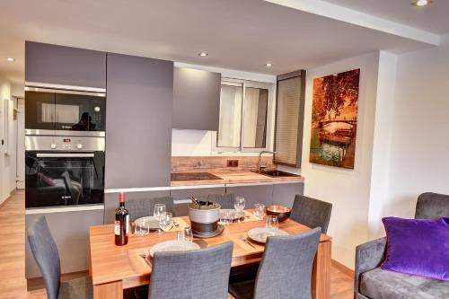 une cuisine et une salle à manger avec une table et des chaises en bois dans l'établissement Cozy apartment between lake and mountains, à Annecy