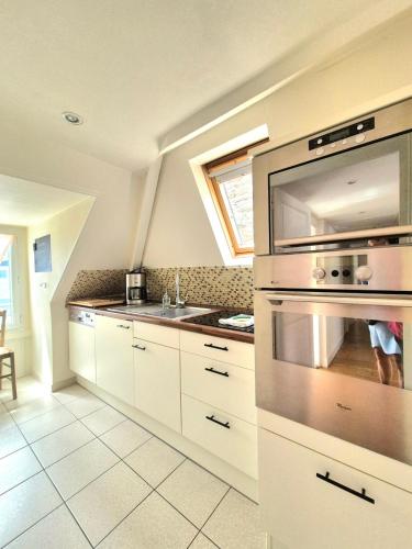 une cuisine avec un évier et une cuisinière four supérieur dans l'établissement 2 bedroom apartment - close to the beach, à Dinard