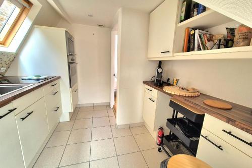 une cuisine avec des armoires blanches et un comptoir dans l'établissement 2 bedroom apartment - close to the beach, à Dinard