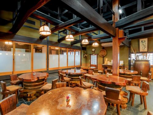 an empty restaurant with wooden tables and chairs at 料理旅館 山里料理 いそべ -Ryokan Isobe- in Kami-hiraya