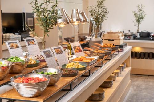 a buffet line with bowls of food on display at HOTEL MYSTAYS Kumamoto Riverside in Kumamoto