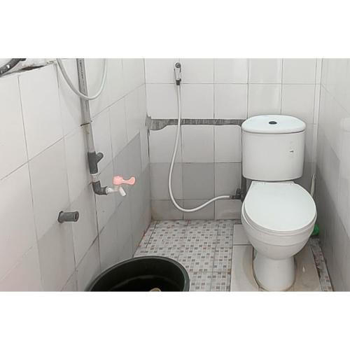 a bathroom with a toilet and a bucket at RedDoorz at Linggarjati Kuningan in Kuningan