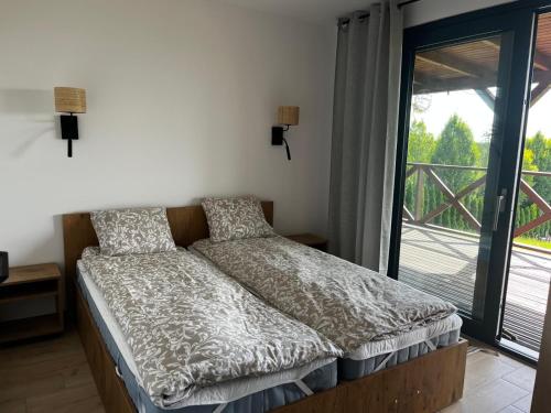 PrabutyにあるSielskie Wakacjeの大きな窓のある部屋のベッド