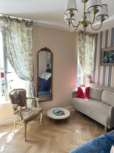 un salon avec un canapé et un miroir dans l'établissement Évasion Parisienne !, à Paris