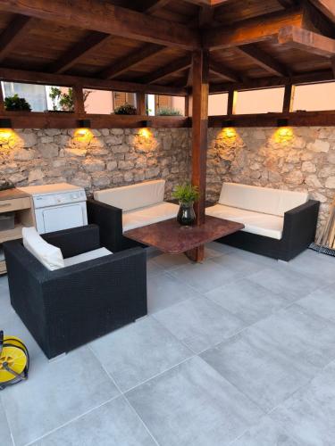 a patio with two couches and a stone wall at Villa bella in Mali Lošinj