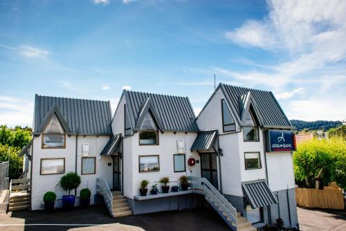 a white house with a gray roof at Aria on Bank in Dunedin
