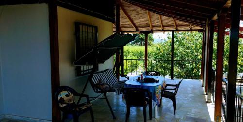 a dining room with a table and chairs on a patio at ORFANIDISHAUS 300 m απο παραλια ΟΡΦΑΝΙΟΥ - in Orfánion