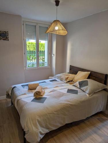 un grand lit dans une chambre avec une lumière dans l'établissement Appartement au cœur des alpes, à Albertville