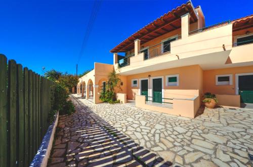 a house with a cobblestone street in front of it at Jasmine Apartments in Sidari