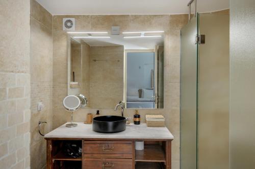 a bathroom with a sink and a shower with a mirror at Blueros Luxury Villa in Megas Yialos-Nites