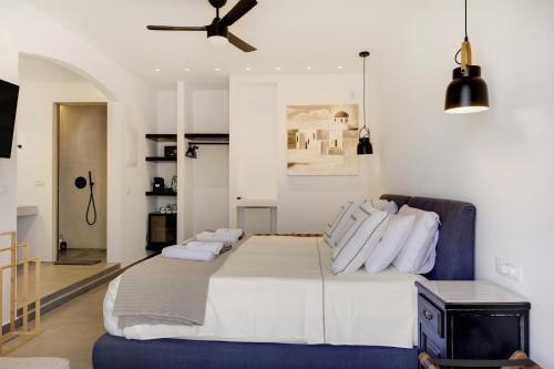 a bedroom with a large bed and a ceiling fan at Blueros Luxury Villa in Megas Yialos-Nites