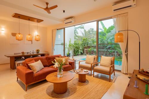 a living room with a couch and chairs at ELIVAAS 3 BHK with Pvt outdoor Pool - Mirai Gemini in Vagator