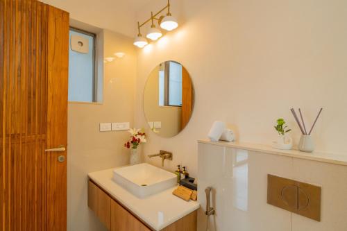 a bathroom with a sink and a mirror at ELIVAAS 3 BHK with Pvt outdoor Pool - Mirai Gemini in Vagator