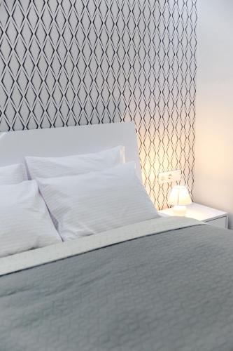 a bedroom with a white bed with a wall at Old City apart in Lviv