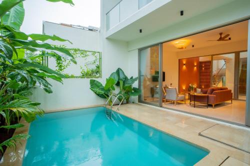 a swimming pool in a house with a living room at ELIVAAS 3 BHK with Pvt outdoor Pool - Mirai Gemini in Vagator