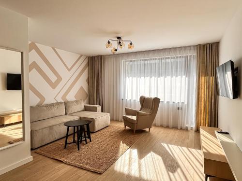 a living room with a couch and a chair at Grand Chalet Aparthotel in Poiana Brasov