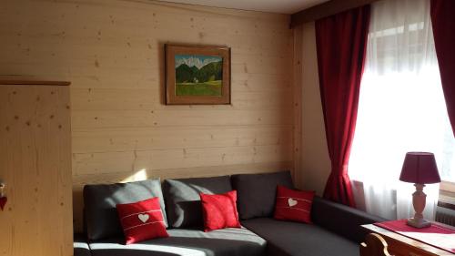 a living room with a couch with red pillows at Casa Monteggia in Dobbiaco