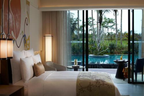 a bedroom with a large bed and a large window at Renaissance Sanya Haitang Bay Resort in Sanya