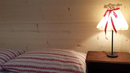 a lamp sitting on a table next to a bed at Casa Monteggia in Dobbiaco