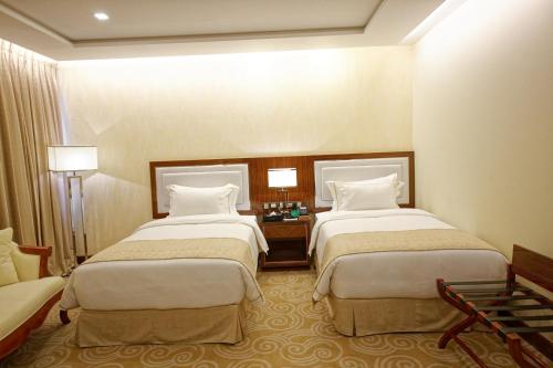 a hotel room with two beds and a couch at Royal Swiss Lahore in Lahore