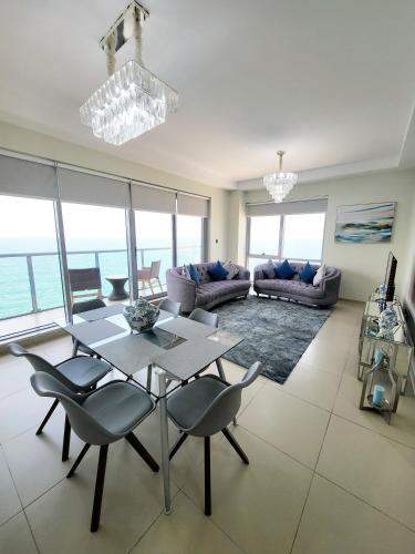 a living room with a table and chairs at Luxurious 2 bedroom Beachfront Apartment - direct seaview in Ras al Khaimah