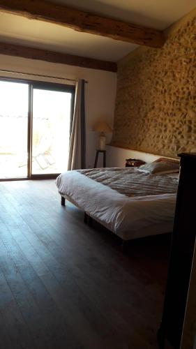 une chambre avec un lit et une grande fenêtre dans l'établissement Chambre à la ferme au milieu des lavandes, à Valensole