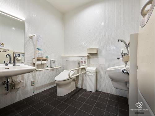 a bathroom with a toilet and a sink at Daiwa Roynet Hotel Kyoto-Hachijoguchi in Kyoto
