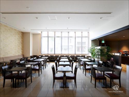 a restaurant with tables and chairs and a large window at Daiwa Roynet Hotel Kyoto-Hachijoguchi in Kyoto