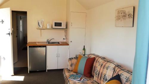 a living room with a couch and a kitchen at Villa Shakespeare in Cambridge