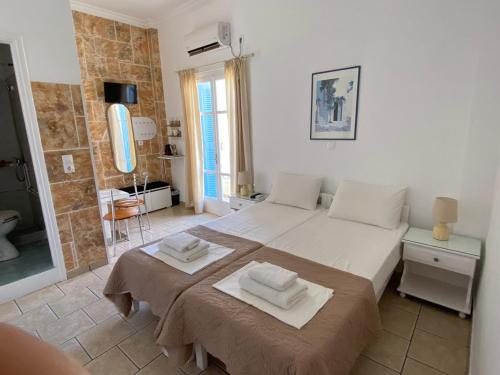 a bedroom with a bed with two towels on it at ERRIKA in Ermoupoli