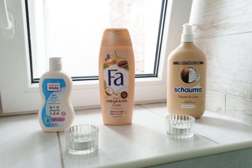 a shelf with two bottles of detergent and two glasses at Lara free parking Skadarlija in Belgrade