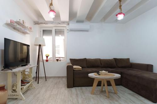 a living room with a brown couch and a table at Lara free parking Skadarlija in Belgrade