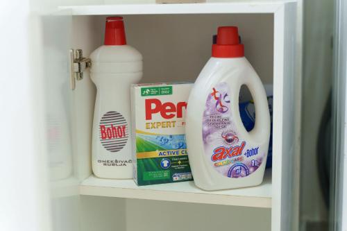 two bottles of milk and detergent sitting on a shelf in a refrigerator at Lara free parking Skadarlija in Belgrade