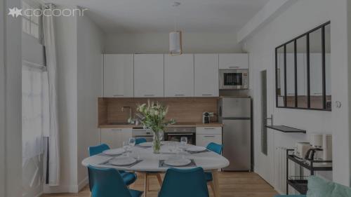 - une cuisine avec une table et des chaises bleues dans la chambre dans l'établissement Les Lauriers - dans l'Intramuros, à Saint-Malo