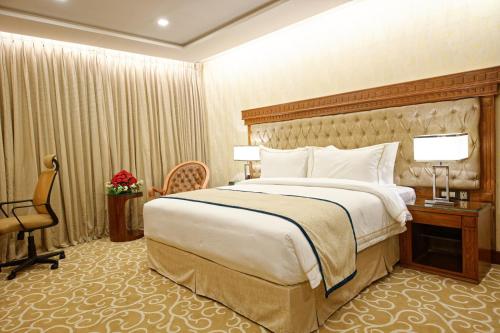 a hotel room with a large bed and a desk at Royal Swiss Lahore in Lahore