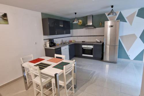 a kitchen with a table with chairs and a refrigerator at Le PORT MIOU près calanques de Cassis 2 chambres 6 personnes in Carnoux