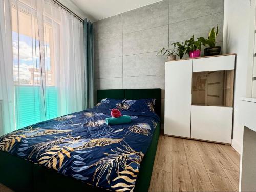 a bedroom with a bed with a blue comforter at Apartament VICTORIA Olecko in Olecko
