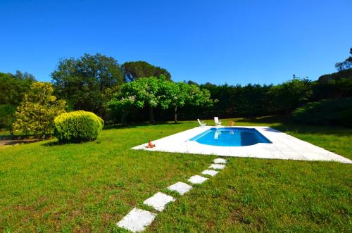 a swimming pool in the middle of a grass field at Can Torrent 10 Km Lloret De Mar in Vidreres