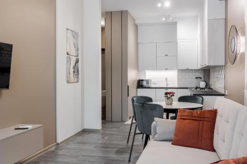 a kitchen and a living room with a table and chairs at FORUM apart in Lviv
