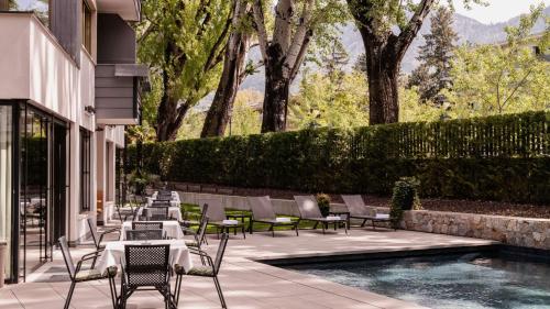 a row of chairs and tables next to a swimming pool at Flora Hotel & Suites in Merano