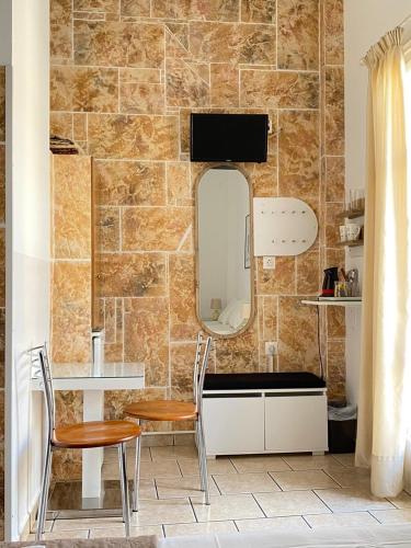 a bathroom with two chairs and a mirror on a wall at ERRIKA in Ermoupoli