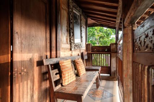a porch with a wooden bench on a house at TwoSpaces Living at Bunga Desa, Jimbaran in Jimbaran