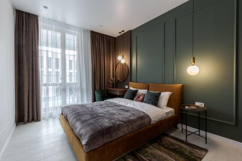 a bedroom with a large bed and a large window at FORUM apart in Lviv