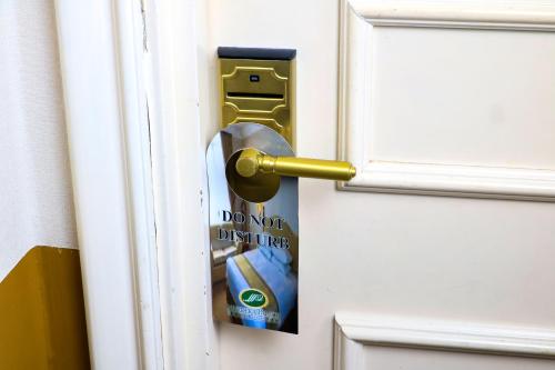 a sticker on a door with a doorknob at Merdeka Palace Hotel & Suites in Kuching