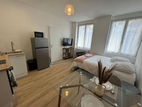 un salon avec un lit et une table en verre dans l'établissement Le studio Champêtre, à Mulhouse