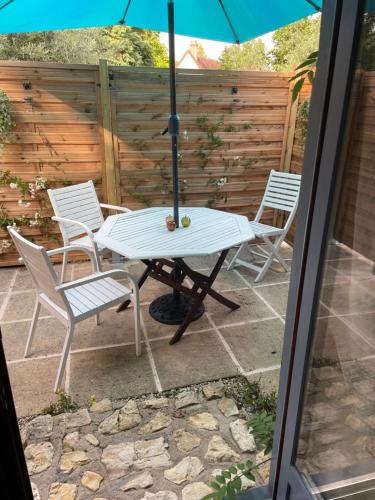 a table and chairs and an umbrella on a patio at Lavender Cottage in Chézelles