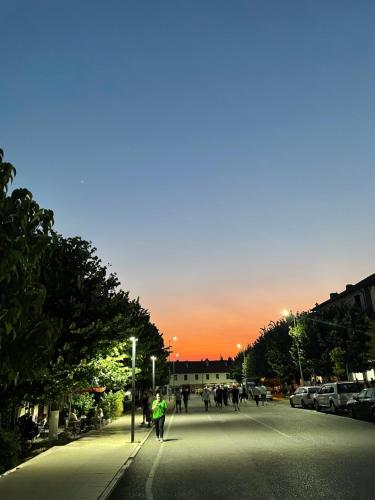 a group of people walking down a street at sunset at Riza Guest House in Pukë