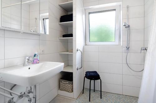 une salle de bain blanche avec lavabo et douche dans l'établissement Fewo Fuchs, à Salem