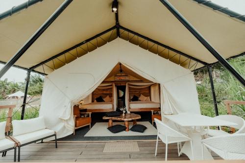 a tent with a bed and a table and chairs at Campgrounds at Mantalongon in Dalaguete